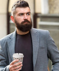 Man holding coffee cup with Skinny Black Plastic Sip Stirrer Straws for Coffee and Cocktails in a gray suit outside.