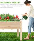 Woman watering Raised Garden Bed On A Sturdy Wood Stand With Drainage And Bed Liner, Elevated Planter Box For Kids And Backyard Patio Veggies, 34 By 18 By 30 Inches, 150 Pound Capacity, Natural Finish