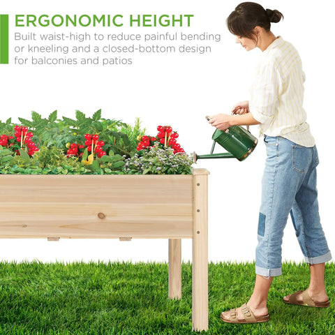 Woman watering Raised Garden Bed On A Sturdy Wood Stand With Drainage And Bed Liner, Elevated Planter Box For Kids And Backyard Patio Veggies, 34 By 18 By 30 Inches, 150 Pound Capacity, Natural Finish