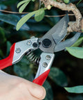 Pro Grade 8 Inch Bypass Pruning Shears With Japanese SK5 Steel Blades cutting a branch, PVC handles visible