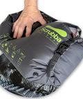 Lightweight Portable Travel Laundry Bag With Patented Washboard Interior For Quick Machine Quality Clothing Cleaning No Sweat Backpacking RV Road Trips Cruise Vacations And Hotel Stops, showing hand squeezing bag.
