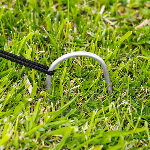 Metal stake securing Pop Up Baseball Batting Cage With Portable Fiberglass Frame And Polyester Netting on grass