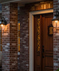 Newbury 14 Inch Outdoor Wall Lantern in Mystic Black With Clear Beveled Glass illuminating a brick porch at night