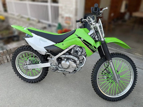 Green dirt bike on pavement with 72Pcs Universal Wheel Spoke Wraps Skins For Motorcycle Dirt Bike Rims Purple High Temperature Resistant