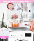 Pink Pegboard Hooks 2 Inch Set With Rubber Safety Tips, Heavy Duty Metal Hangers displayed in a craft room on pegboard.