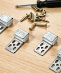 Rock Solid Upholstery Spring Clips Repair Kit For Saggy Couches And Sofas Includes Complete Set Of Carbon Steel Screws With Socket Driver showing metal clips and screws on a wooden surface.