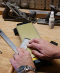 Person sharpening tool on Double Sided Diamond Sharpening Stone With Base DuoSharp 10 Inch Bench Stone Fine And Coarse For Knives And Tools