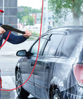 Person using Pressure Washer Gun Replacement With Extension Wand Kit For Electric Washers to clean a car, visible soap spray