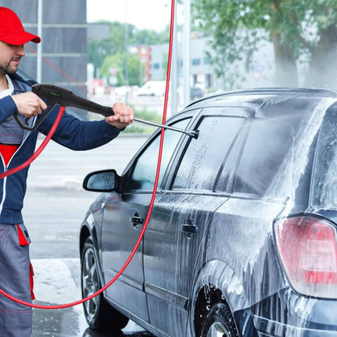 Person using Pressure Washer Gun Replacement With Extension Wand Kit For Electric Washers to clean a car, visible soap spray