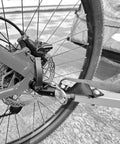 Close-up of angled bike trailer coupler attached to rear wheel of Instep trailer, showcasing durable steel build for universal trailers.