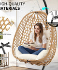 Woman sitting in Egg Chair With Stand Outdoor Patio Wicker Hanging Chair Hammock Swing Seat Cozy Ergonomic Design With Thick Cushion 350 Lbs Capacity For Bedroom Balcony Garden Easy Assembly For Relaxing And Lounging.