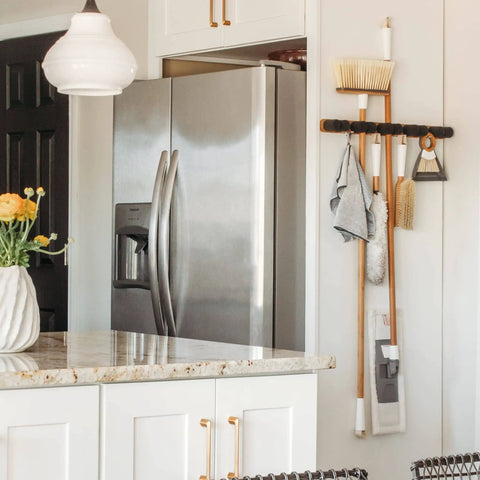 Get A Grip Wall Mounted Mop And Broom Organizer Made Of Lightweight Bamboo With Foam Pegs installed in a kitchen space