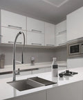 Modern kitchen with sleek white cabinets, stainless steel appliances, and a central island sink with a curved faucet.