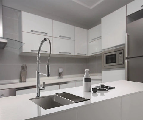 Modern kitchen with sleek white cabinets, stainless steel appliances, and a central island sink with a curved faucet.