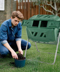 Man using Dual Chamber 43 Gallon Outdoor Compost Tumbler With Sliding Doors And Included Gloves, Rotating Bin For Batch Composting