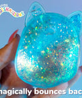 Blue Gelli Gel Squishy Boasting Slow Flow Glitter And Iconic Shape Memory, held in hand showcasing glitter and bouncy texture.