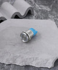 Close-up of Twin Pack 12V IP65 Waterproof LED Flash Buzzer Indicator Light 19mm for electrical panels, blue and silver on stone surface.