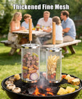 Two Pack Stainless Steel Grill Basket With Removable Beech Wood Handle for vegetables and fish over BBQ grill, family in background