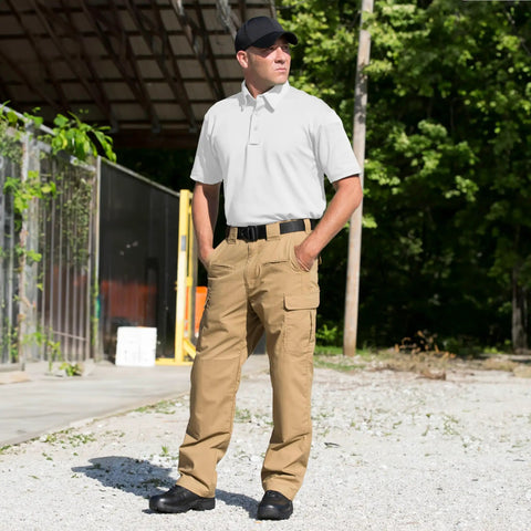 Men Short Sleeve Ice Duty Uniform Polo Shirt With Moisture Wicking Quick Dry Fabric And Concealed Button Down Collar Featuring Mic Clip Slots Plus Pen Pockets For Legit Tactical Gear Built Straight Up Solid Through Long Rough Shifts worn with khaki tactical pants outdoors.