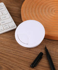 Two Pack White Desk Cable Grommets Sixty Millimeter Abs Plastic Cord Hole Inserts on wooden desk with pen and keyboard.
