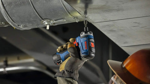 Worker using 12V Max Brushless 1 Quarter Inch Hex Two Speed Screwdriver Kit with Dual 2.0Ah Batteries for overhead assembly