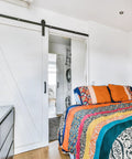 Bedroom with sliding barn door fitted with 4 Pack Barn Door Soft Close Mechanisms With Spring Buffer Dampers.