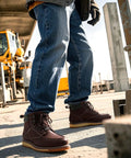 Man wearing Six Inch Waterproof Moc Toe Steel Toe Work Boots For Men With Full Grain Leather Oil And Slip Resistant EH Protection on a construction site