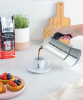 New Venus Induction Stovetop Coffee Maker 6 Cup Stainless Steel Silver pouring espresso into cup with easy pour spout