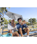 Versa Brella Midnight Blue Outdoor Shade Umbrella With Heavy Duty Clamp for chairs, in use on bleachers providing sun protection