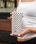 Polka Dot Tumbler Cup 20 Oz French Vanilla Vibes Ceramic Lined Interior Blocks Metallic Flavor Keeps Your Fave Sips Ice Cold Or Damned Hot All Day Long Spill Proof Lid For Commute held by a woman in a casual outfit.