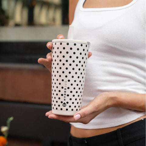 Polka Dot Tumbler Cup 20 Oz French Vanilla Vibes Ceramic Lined Interior Blocks Metallic Flavor Keeps Your Fave Sips Ice Cold Or Damned Hot All Day Long Spill Proof Lid For Commute held by a woman in a casual outfit.