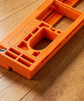 Adjustable Invisible Hinge Router Guide Template Reusable Cabinet Mortise Jig on wooden floor, sturdy orange ABS construction
