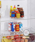 Nine Inch Clear Lazy Susan Set Of Two Round Rotating Turntable Organizers With Non Slip Base For Pantry Cabinet And Fridge Shelf holding condiments and drinks.