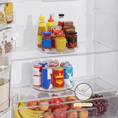 Nine Inch Clear Lazy Susan Set Of Two Round Rotating Turntable Organizers With Non Slip Base For Pantry Cabinet And Fridge Shelf holding condiments and drinks.