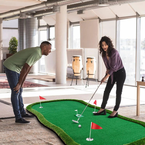 Two people using Pro Grade Golf Putting Green Practice Mat 5x10ft with flags and cups in an office setting.