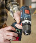 Close-up of One Half Inch Brushless Hammer Drill And Driver Kit With Core 18v 4ah Battery, showing hands adjusting settings.