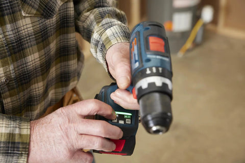 Close-up of One Half Inch Brushless Hammer Drill And Driver Kit With Core 18v 4ah Battery, showing hands adjusting settings.
