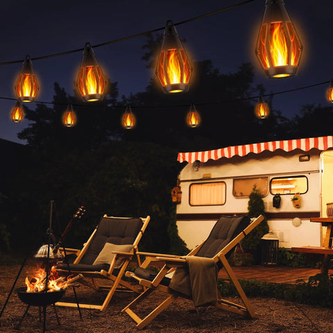 Solar Powered Flickering Flame String Lights For Outdoor Decor 50.7Ft Total Length 15 Warm White LED Bulbs Waterproof Garden Yard Lawn Patio 41.3Ft Flame Wire With 9.35Ft Lead 2.95Ft Bulb Spacing illuminating an outdoor camping scene with chairs and a caravan.