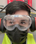 Person wearing Adjustable Safety Ear Muffs Hearing Protection NRR 26 dB Universal Fit with goggles in a work environment