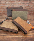 Four Waxed Canvas Tool Pouches 4 Pack, 11-Inch Heavy-Duty Zipper Tool Bags with tools, against brick wall background