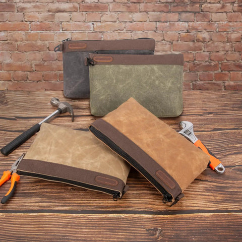 Four Waxed Canvas Tool Pouches 4 Pack, 11-Inch Heavy-Duty Zipper Tool Bags with tools, against brick wall background