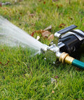 1/10HP Electric Water Transfer Pump With Two 6Ft Garden Hoses spraying water on grass, compact design for yard cleanup.