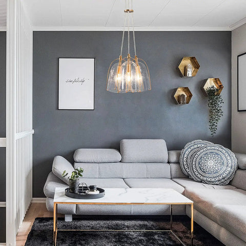 Gold Modern 3-Light Pendant Chandelier With Seeded Glass Shades in stylish living room with gray sofa and geometric decor