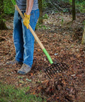 61 Inch Heavy Duty 10 Tine Welded Steel Bedding Fork Workhorse with hardwood handle in use on leaves in a garden setting