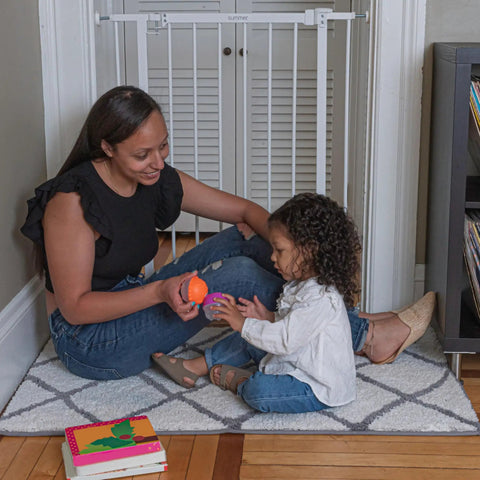 Woman and child playing on floor next to Everywhere Extra Tall and Wide Baby and Pet Gate for Doorways, Halls, and Stairs, Adjustable 28.75 to 39.75 Inch Wide, 36 Inch Tall, Pressure or Hardware Mounted, Easy In-Between Rooms Install, White Metal.
