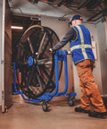 Man moving Six Foot Heavy Duty Mobile Industrial Barrel Fan Pumping Forty Thousand CFM Of Big Air Punch with smooth caster base.