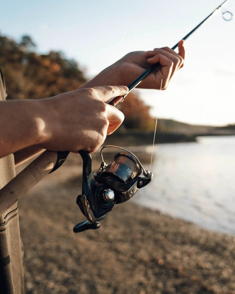 Angler using the Crossfire LT Spinning Reel With AIRDRIVE Design for effortless casts by a lakeside.