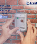 Hand holding Metal Weatherproof Electrical Outlet Box 1 Gang With Three 1/2-Inch Knockouts against a brick wall