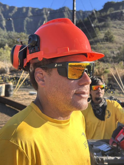 Person wearing Go-To Safety Sunglasses With Polarized Mirror Lenses ANSI Z87 Plus Certified UV 400 Protection, hard hat, and yellow shirt.