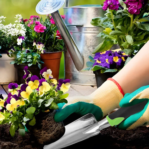 Gardener using Heavy Duty Cast Aluminum Garden Hand Shovel And Trowel for planting flowers in soil, surrounded by blooming plants.
